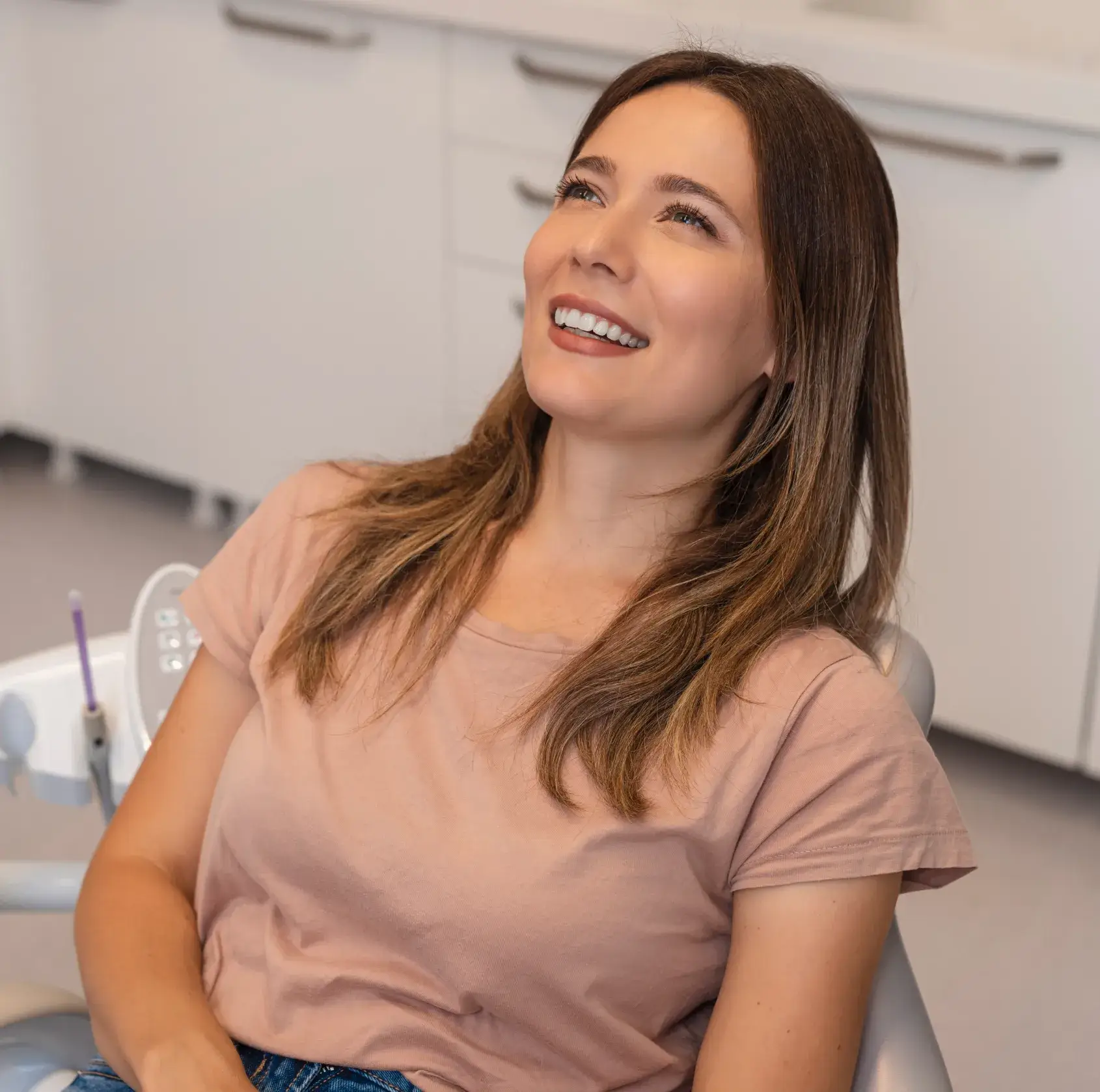 A woman sitting in a dental chair smiling.