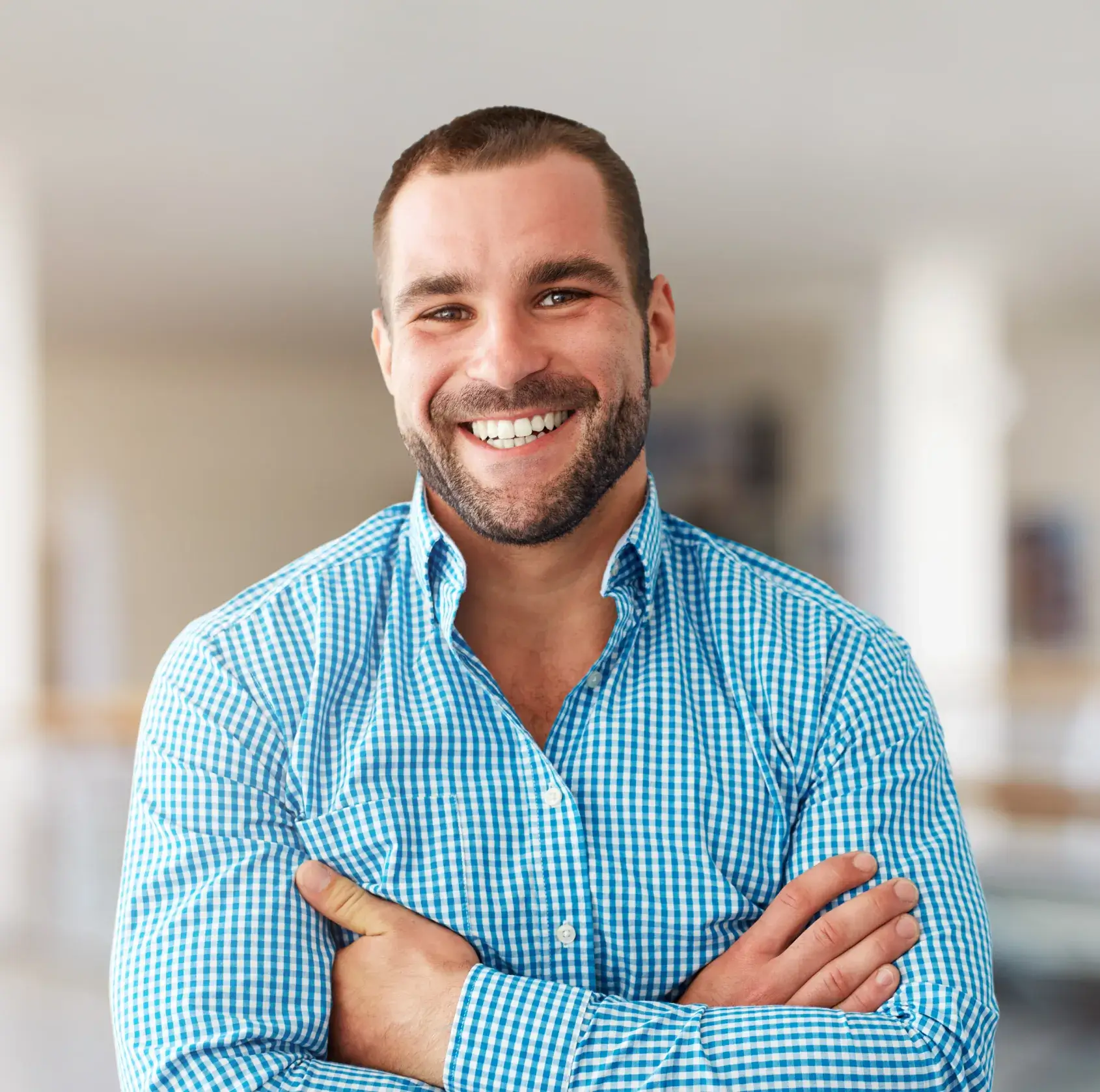 A man with his arms crossed smiling.