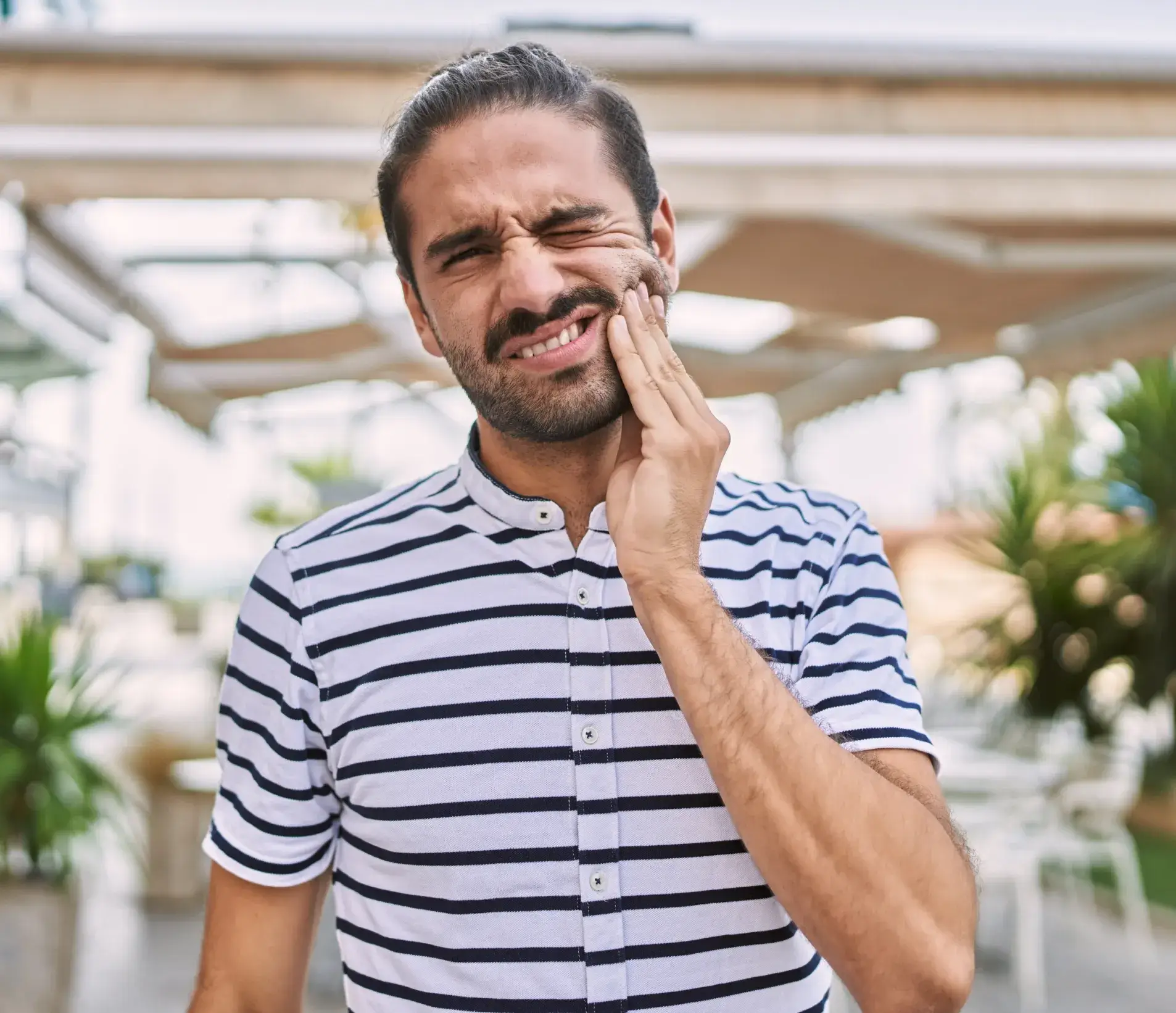 A man holding his hand to his face.