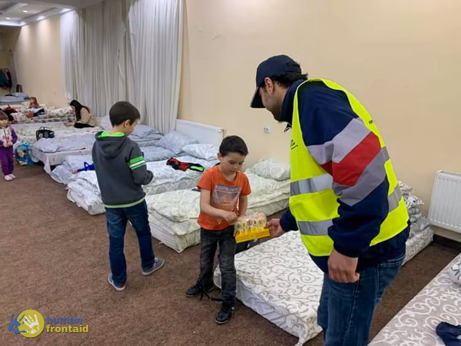 Eingestürztes Wohngebäude bei Nacht mit Rauch, Feuerwehrleute und Rettungskräfte beim Einsatz im Trümmerfeld.