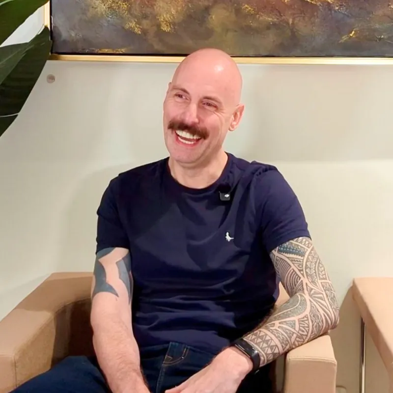 Simon Stone smiling with his new teeth after treatment with Implantly