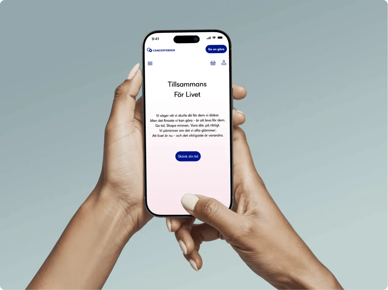 Hands holding a smartphone displaying the hero screen of Cancerfonden’s ‘Dör För Dig’ campaign with the message ‘Tillsammans För Livet.