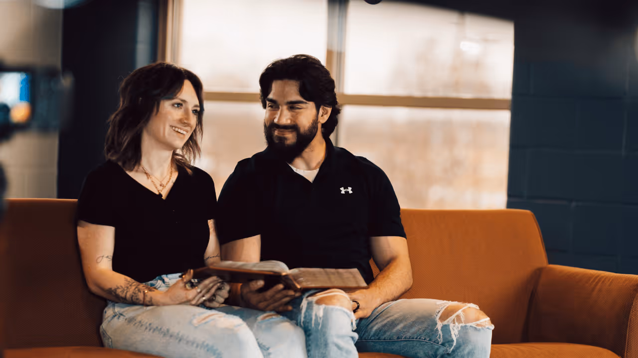 Man and women sitting on couch with Bible open