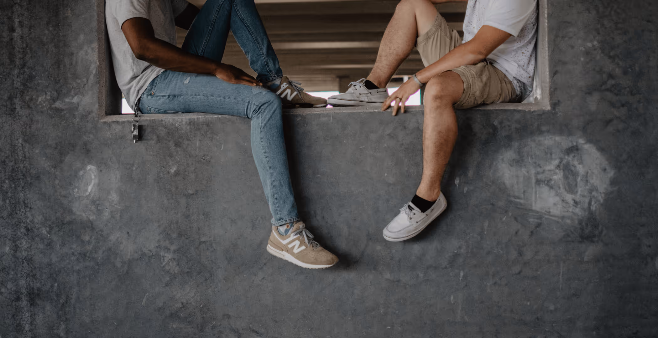 Two men sitting on concrete wall