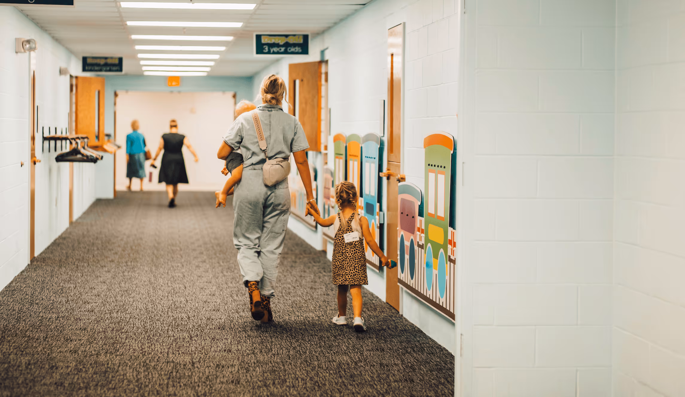 Mom and kids walking down hallway at church