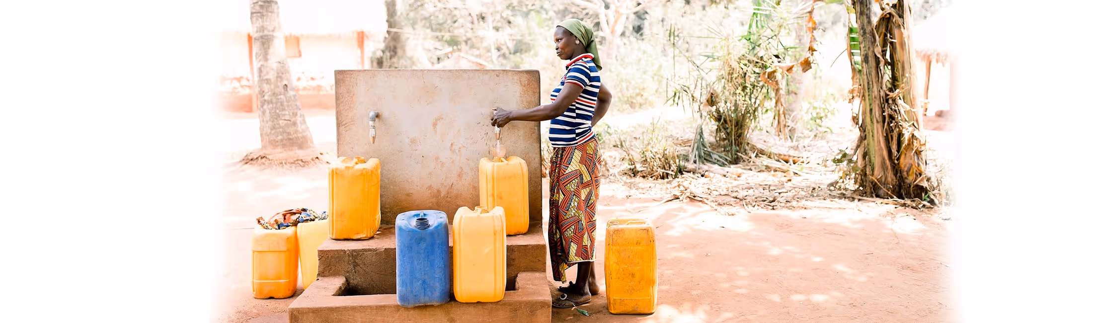 women filling up water jugs at a fountain