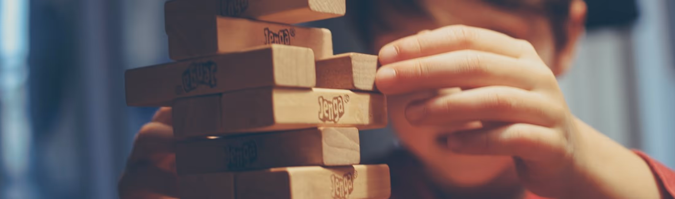 child stacking jenga blocks