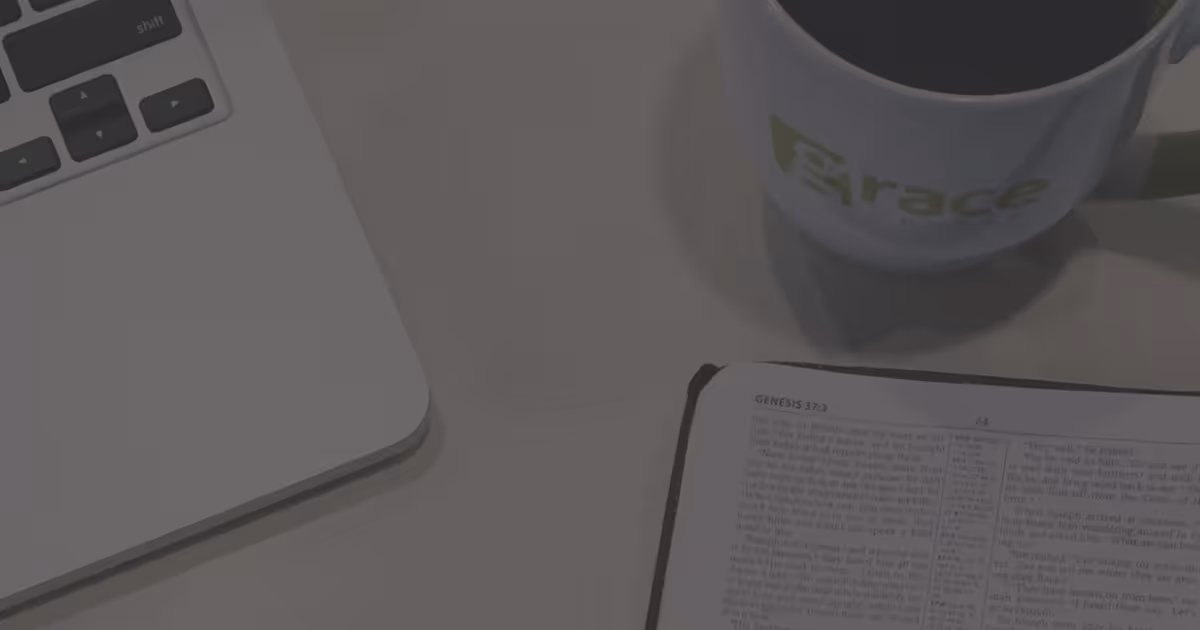 Coffee mug, Bible, and laptop on table
