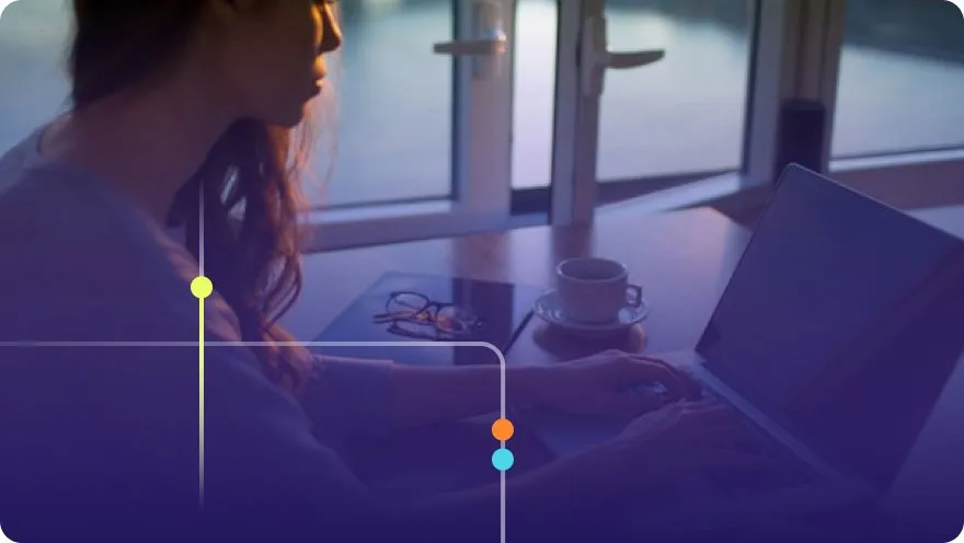 Woman working on a laptop at a cafe table with coffee and glasses nearby, purple overlay