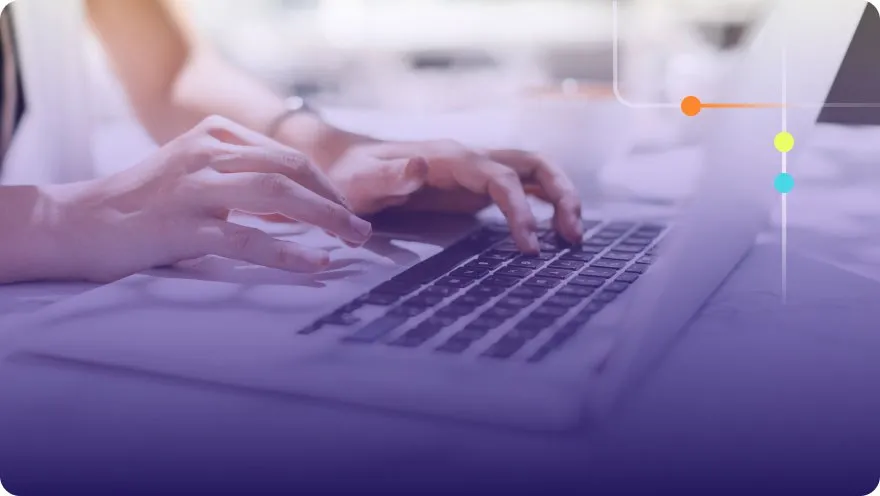 Close-up of hands typing on a laptop keyboard with a soft purple overlay