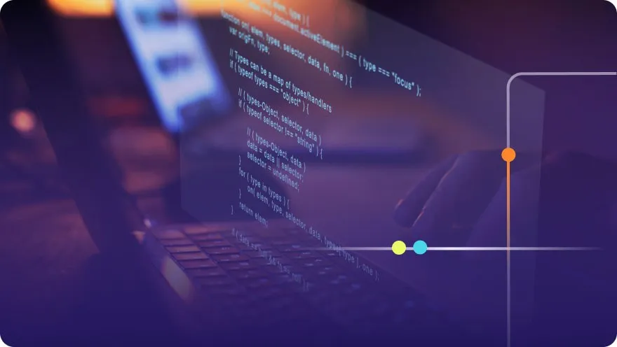 Laptop keyboard with JavaScript code projected on the screen in a dark setting