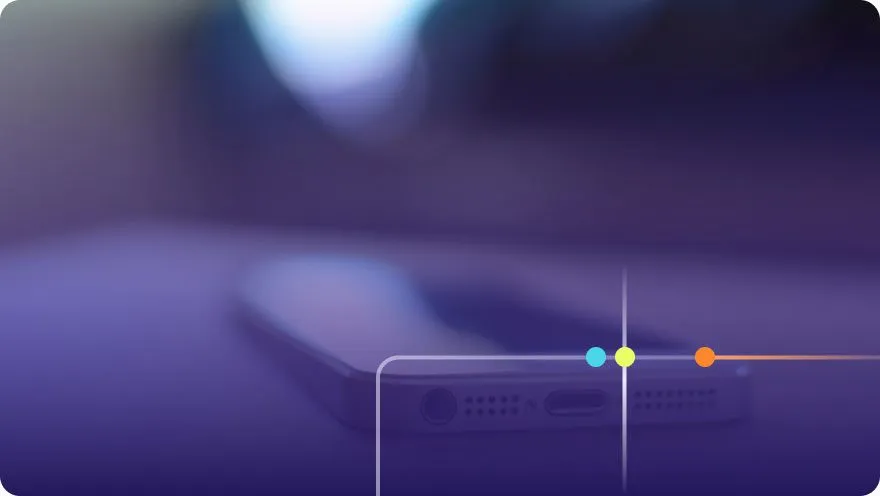 Close-up of a smartphone lying on a dark surface with soft bokeh lighting