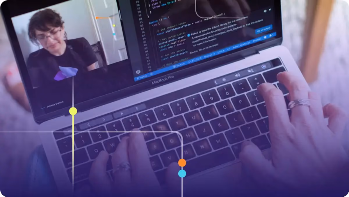 Person coding on a MacBook Pro with a video call and code editor visible on screen