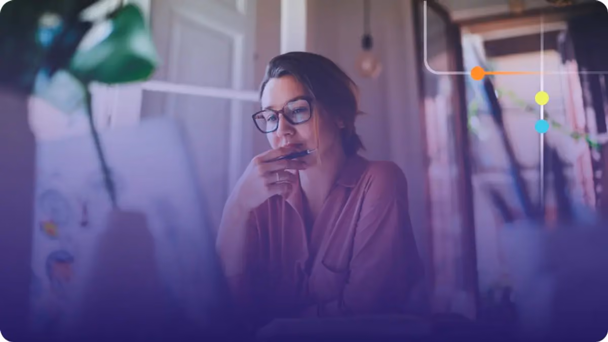 Woman with glasses holding a pen in thought at a desk with a purple overlay