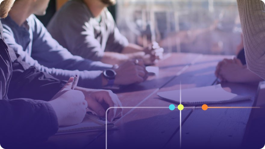 People sitting at a conference table taking notes during a meeting with a purple overlay