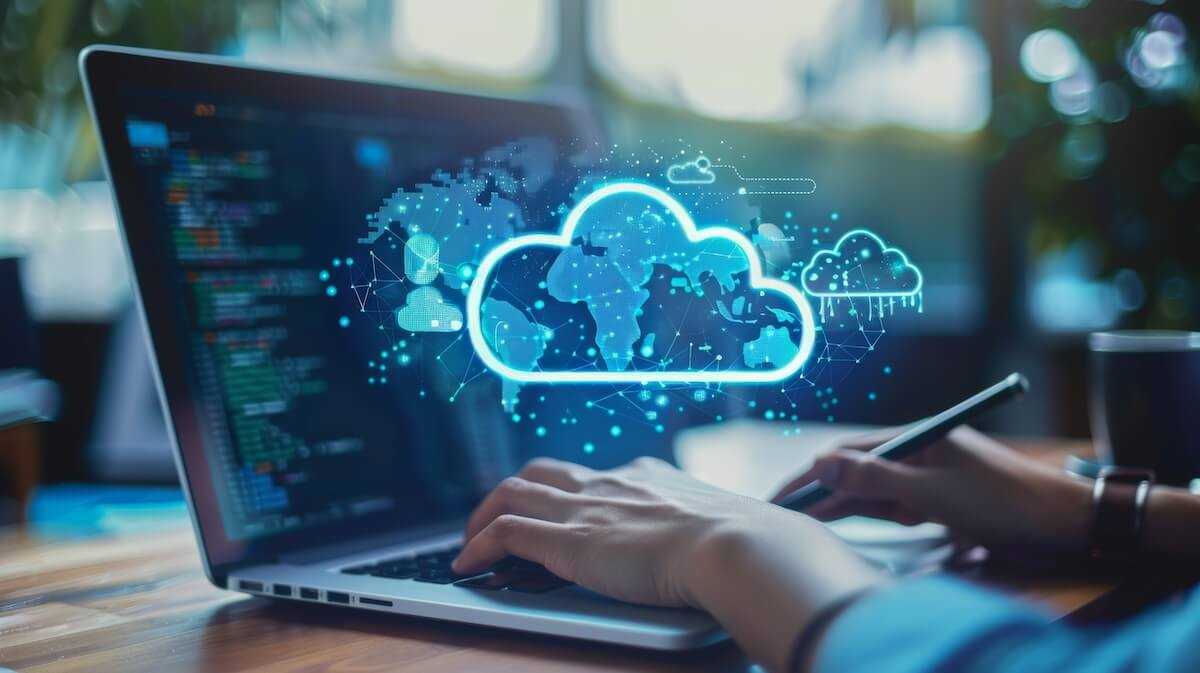 Person typing on a laptop with a glowing cloud computing hologram floating above the keyboard