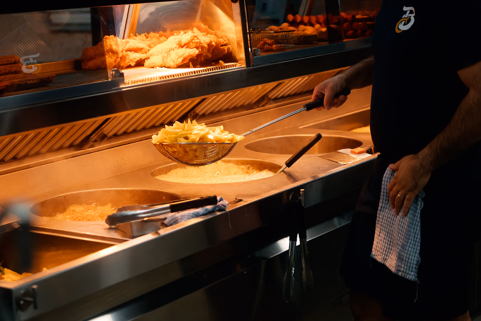 Person cooking with fryers for chips