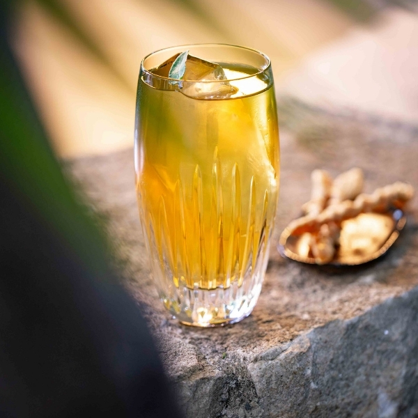 Cocktail jaune aux agrumes servi dans un verre haut