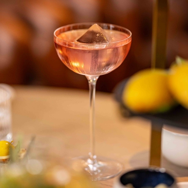 Cocktail ambré servi dans un verre élégant sur comptoir en bois