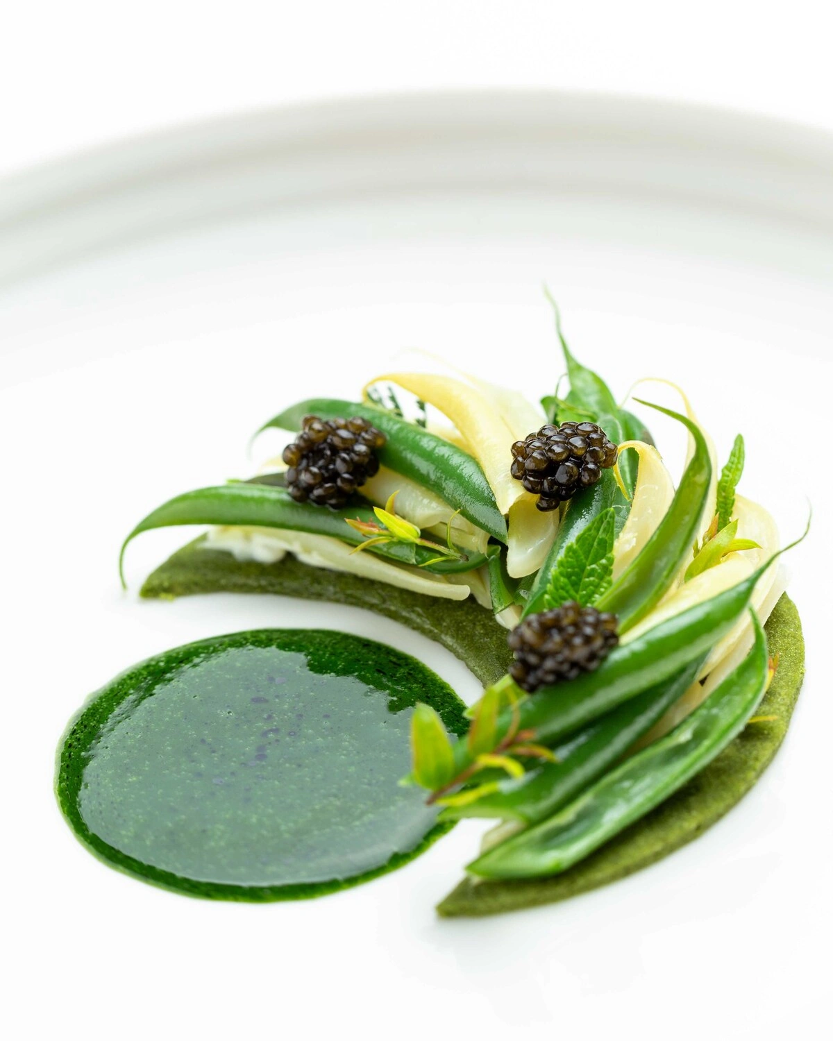 Création gastronomique de légumes verts et caviar, une signature d'Anne-Sophie Pic à Dubai.