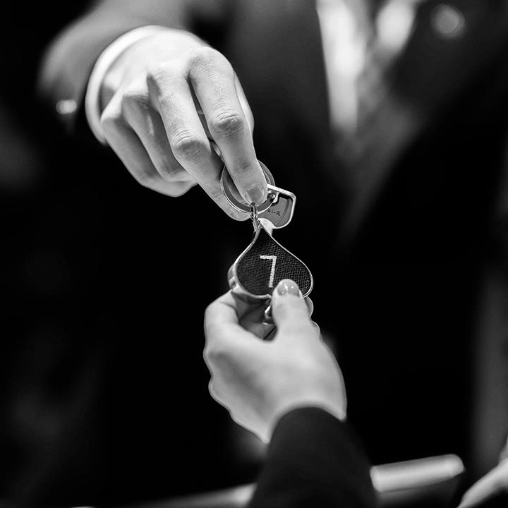 Réceptionniste remettant une clé de chambre à un client à l’accueil de l’hôtel