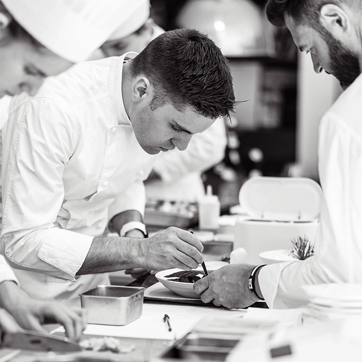 Pâtissier décorant un dessert avec précision en cuisine