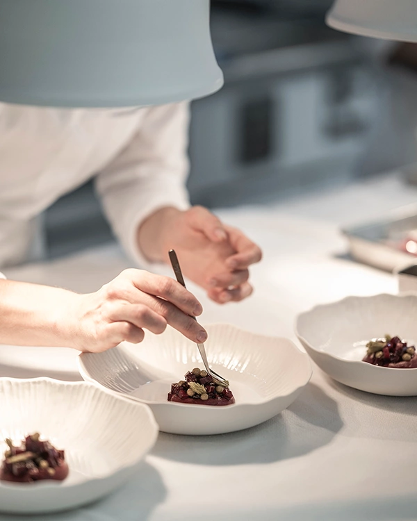 Dressage minutieux d’une assiette en cuisine au Restaurant Pic