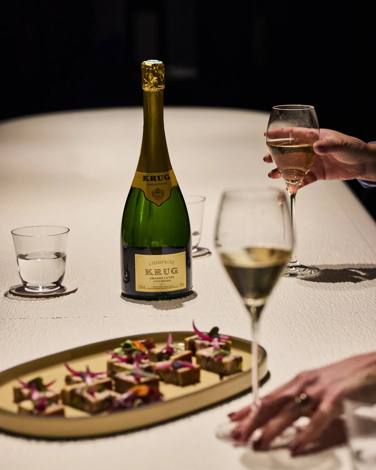 Dégustation de champagne et tapas sur une table de La Cave Pic à Valence.