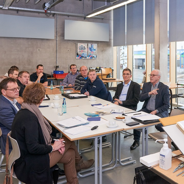 Besprechung an Tisch mit vielen Leuten