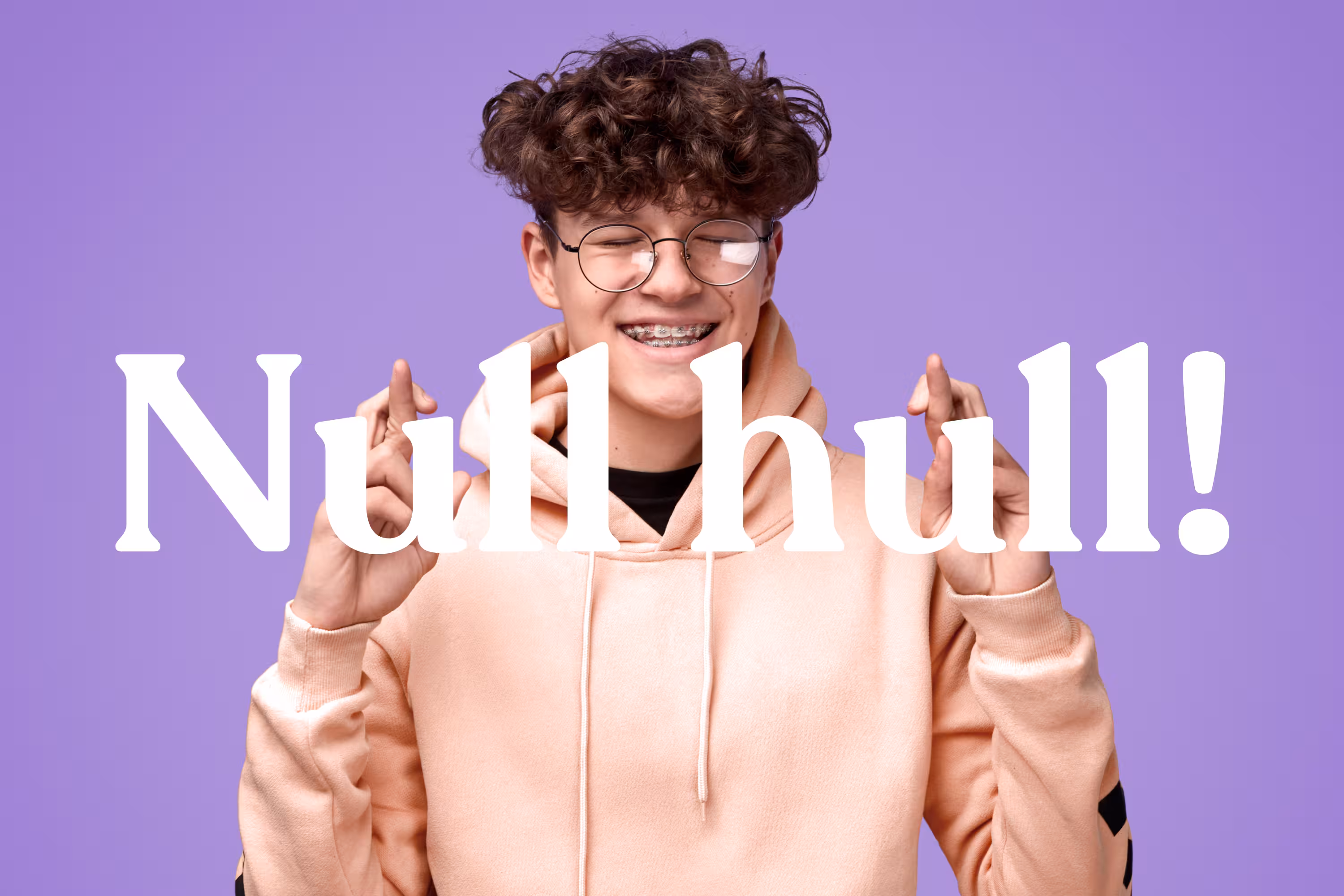 Smiling young man with curly hair and braces wearing round glasses and a peach hoodie, crossing his fingers with both hands against a purple background with the word 'Nullhull!' overlayed, meaning "Zero holes!" in norwegian.