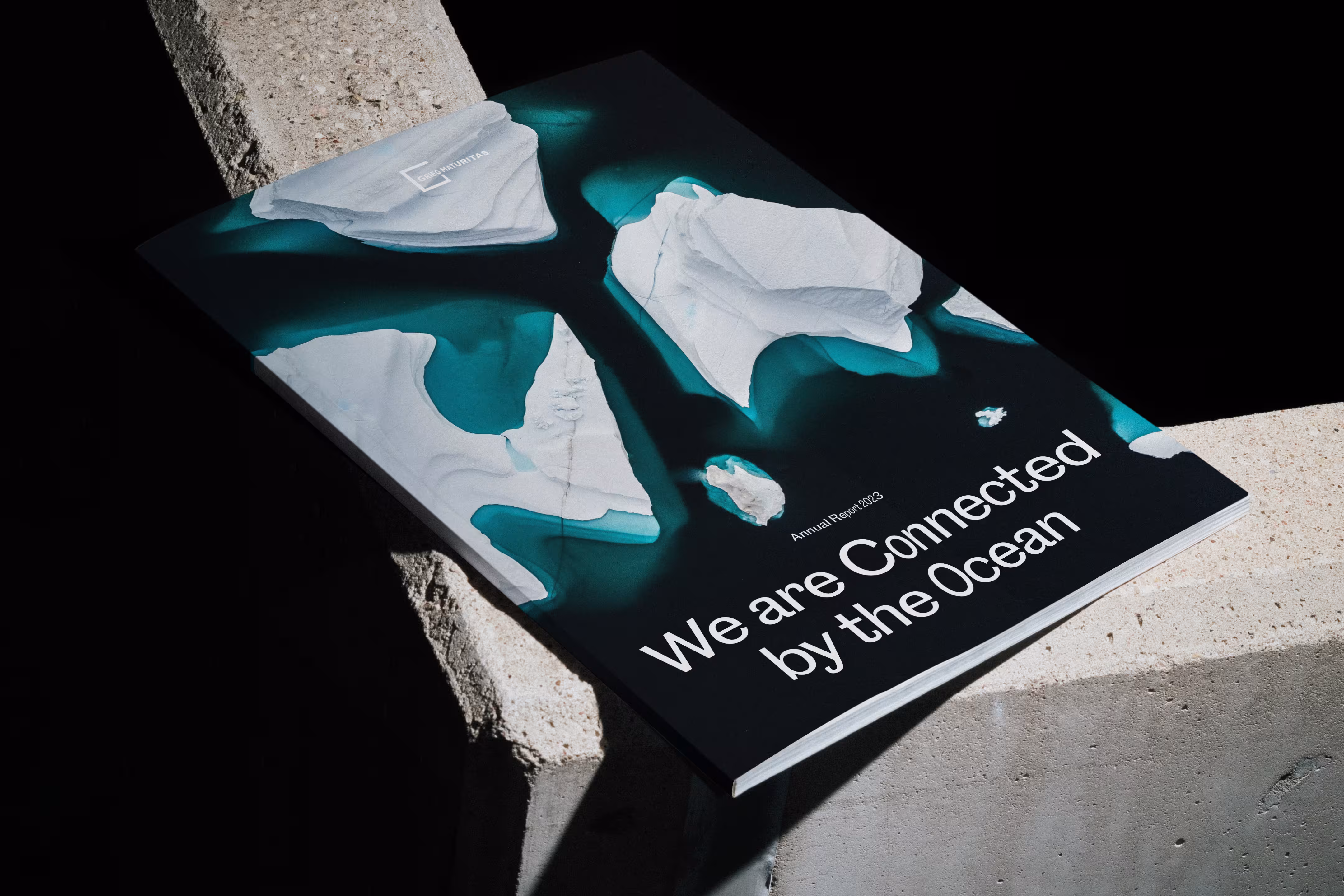 Grieg Maturitas' annual report 2023 laying on a concrete wall in a beautiful light