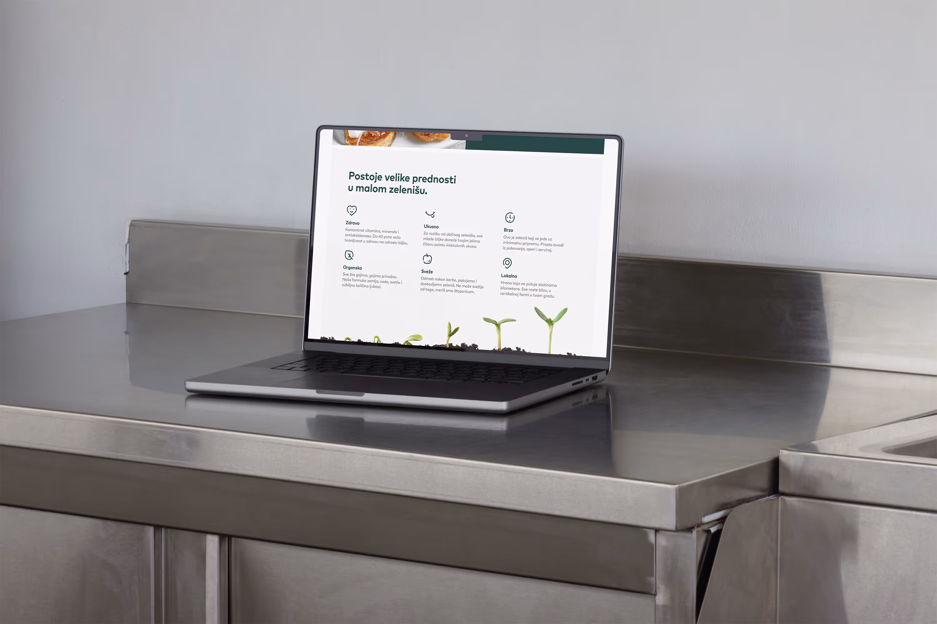 A laptop laying on the metal kitchen table showing a section from Neri's website