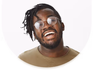 Smiling young man with glasses and dreadlocks against a white background.