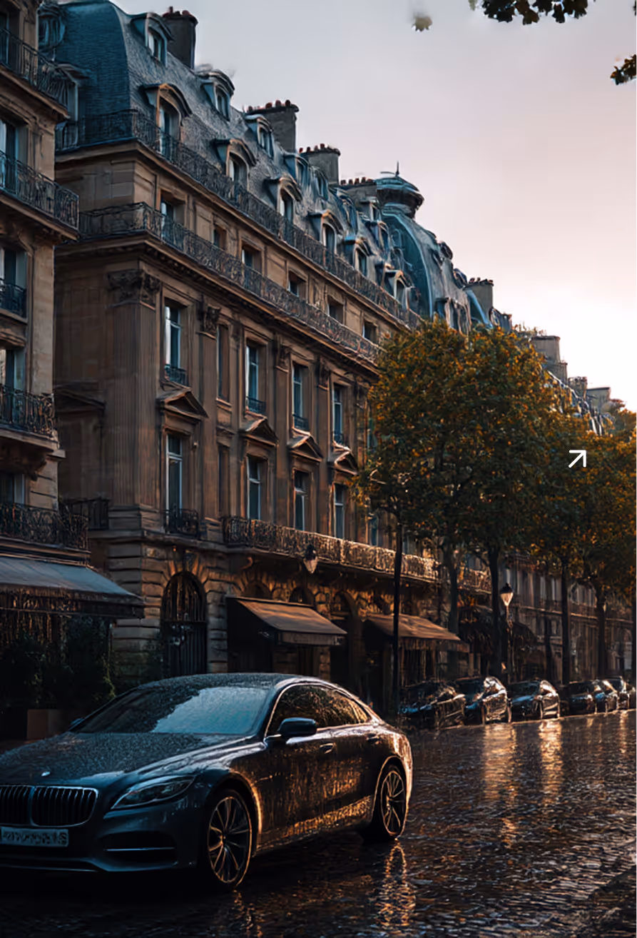 Voiture noire stationnée sur une rue pavée mouillée devant un bâtiment haussmannien avec des balcons en fer forgé et des arbres éclairés par un coucher de soleil.