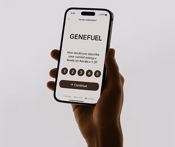 Hand holding a smartphone displaying an online assessment screen titled 'GENEFUEL' asking to rate current energy levels on a scale of 1 to 5 with a continue button below.