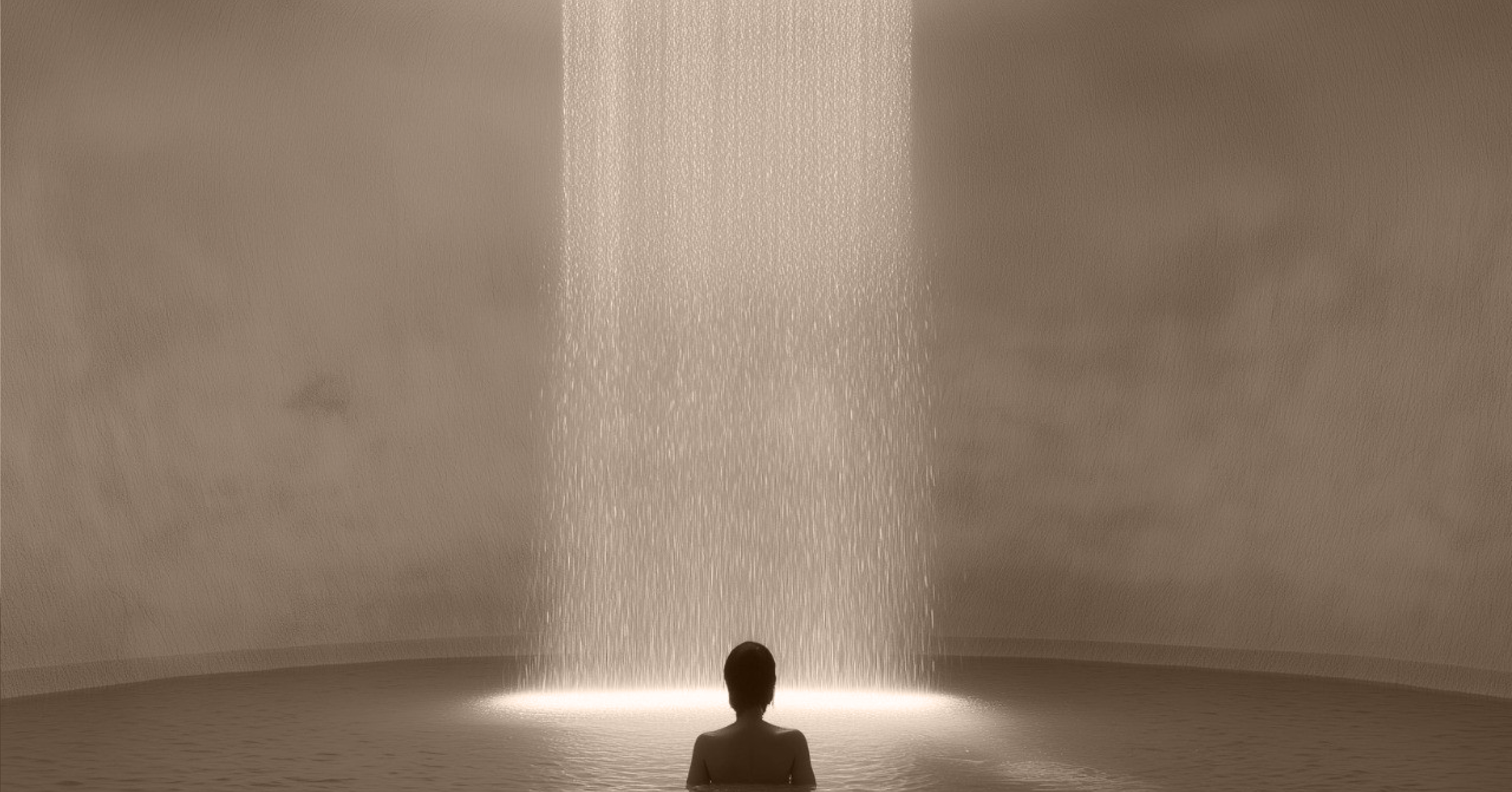 Silhouette of person facing a bright column of falling water inside a circular pool.