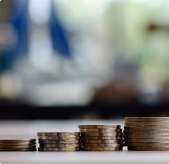 Stacks of coins arranged in ascending order on a flat surface with a blurred background.