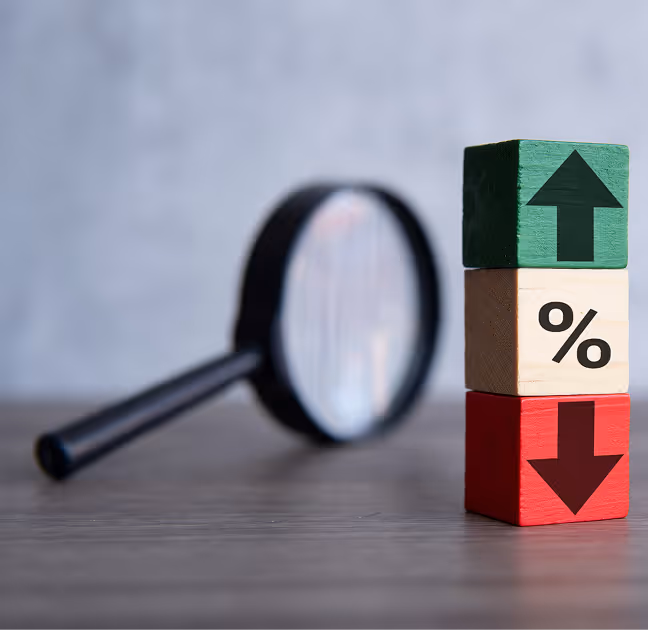 Two business professionals shaking hands in a warehouse with shelves of boxes, one holding a clipboard with documents.