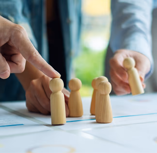 White miniature figures of diverse people placed on a dark blue circuit board background with white connecting lines.