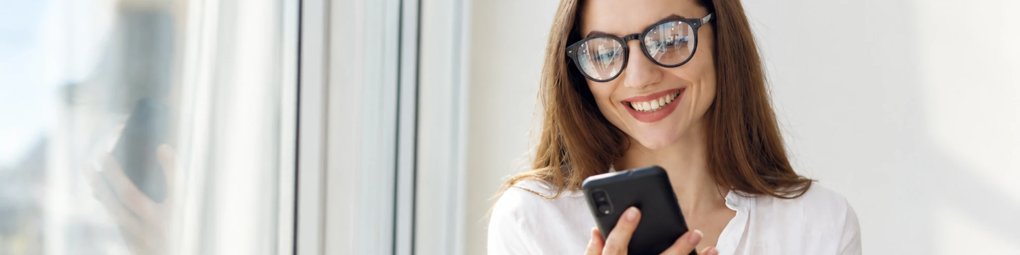 Vrouw kijkt lachend naar mobiel