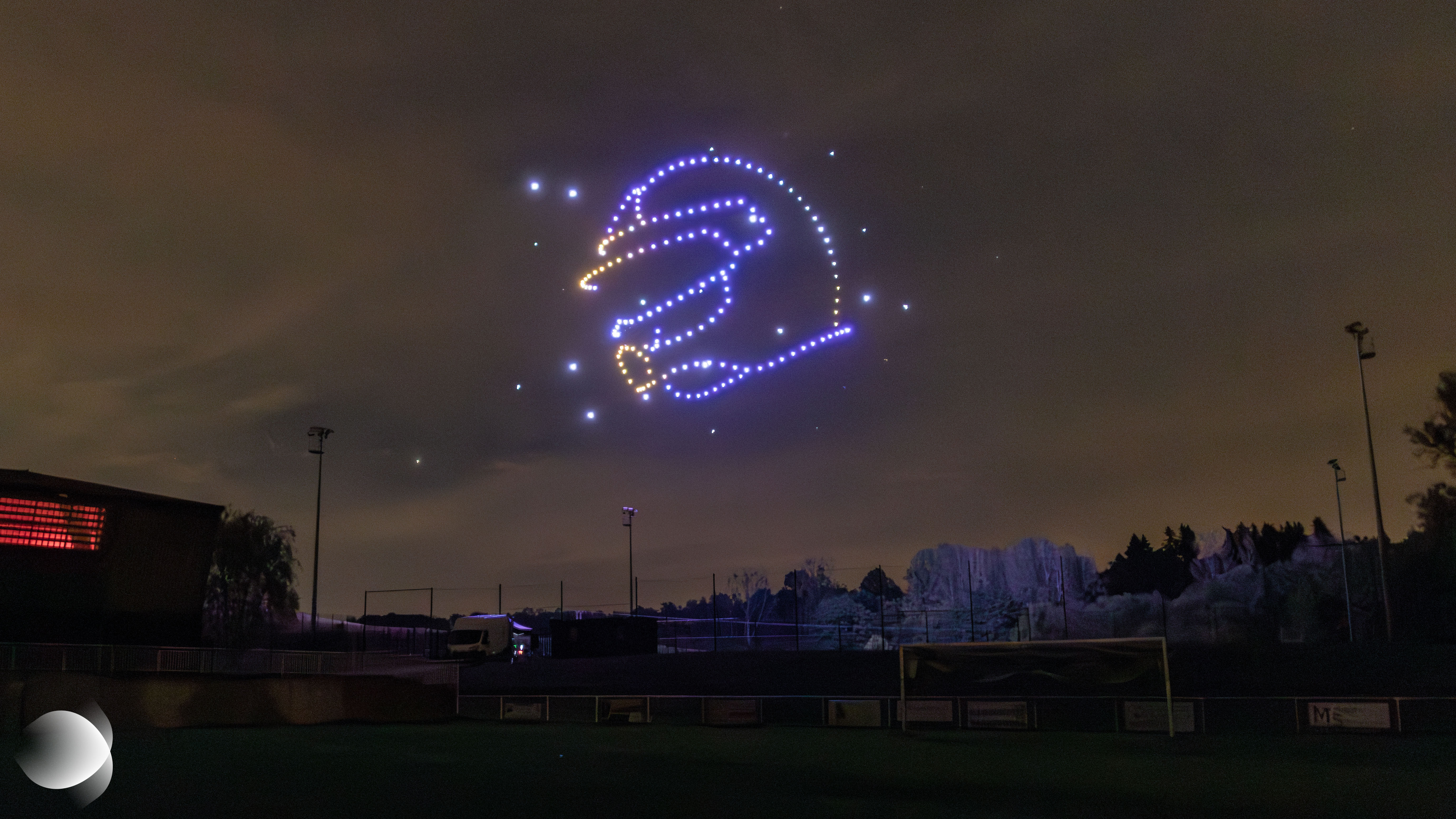 Casque de pilote de rallye dessiné dans le ciel nocturne par des drones lumineux lors du spectacle célébrant le 20e anniversaire du Rallye d’Alsace Bossue à Drulingen, le 19 septembre 2026.