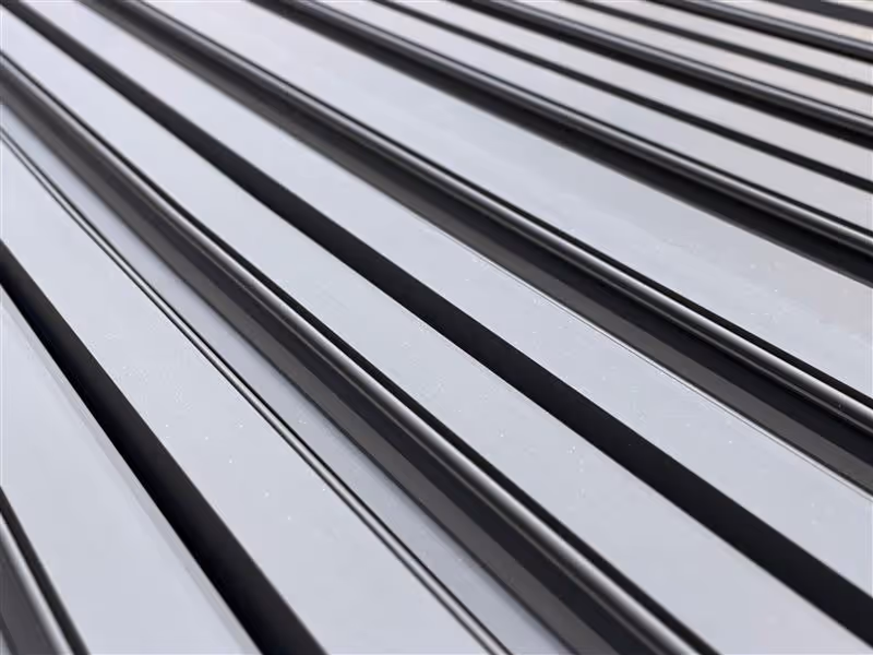 Close-up of parallel metallic slats with smooth surface and narrow gaps.