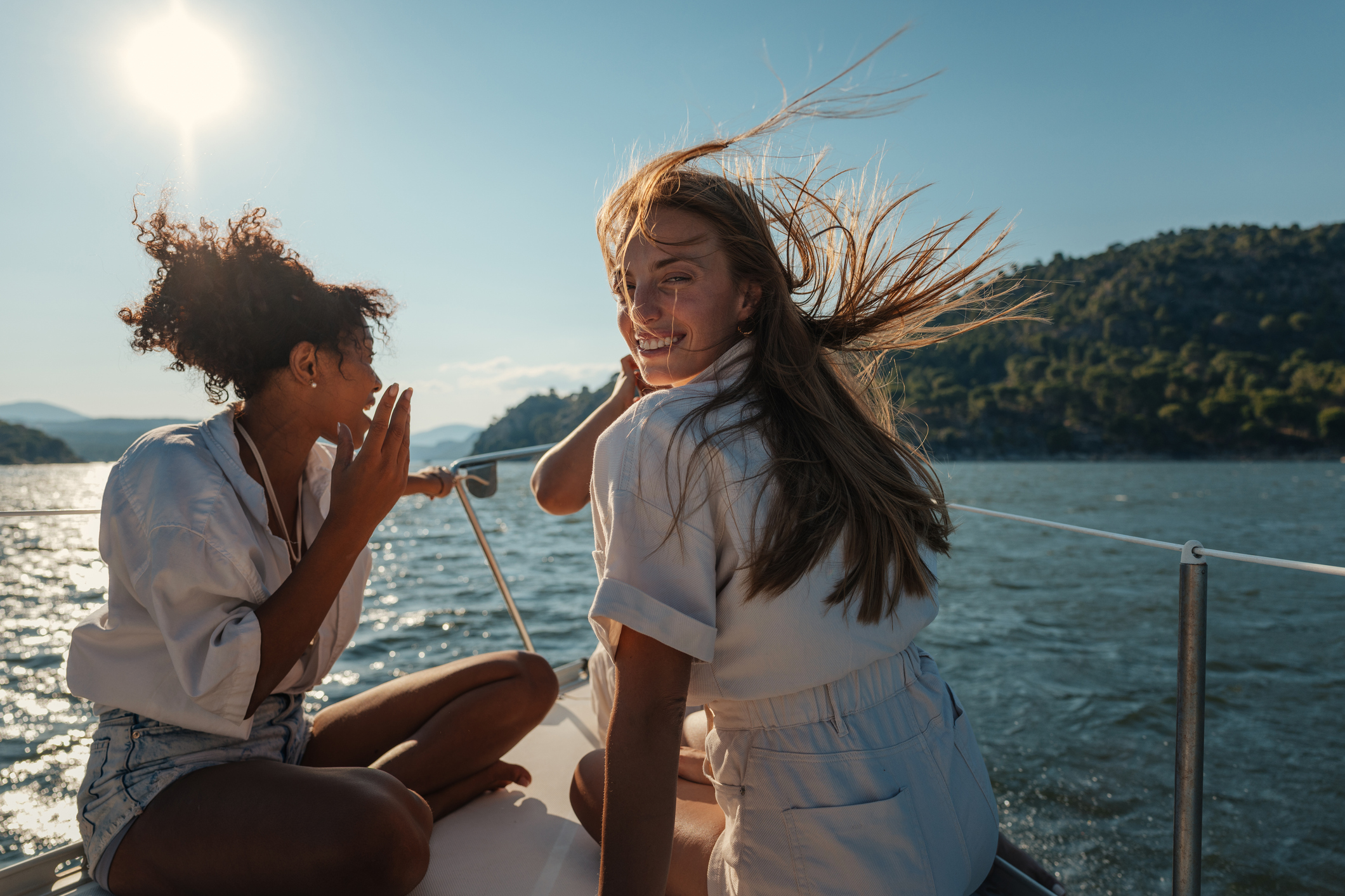Smiling young adult women relaxing on a boat during summer vacation on a fishing charter.