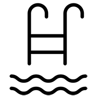 Piscina ao ar livre com borda infinita, cercada por um jardim e cadeiras de descanso.