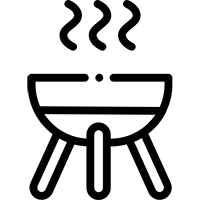 Churrasqueira de tijolos vermelhos com grelha de metal, localizada em área externa.