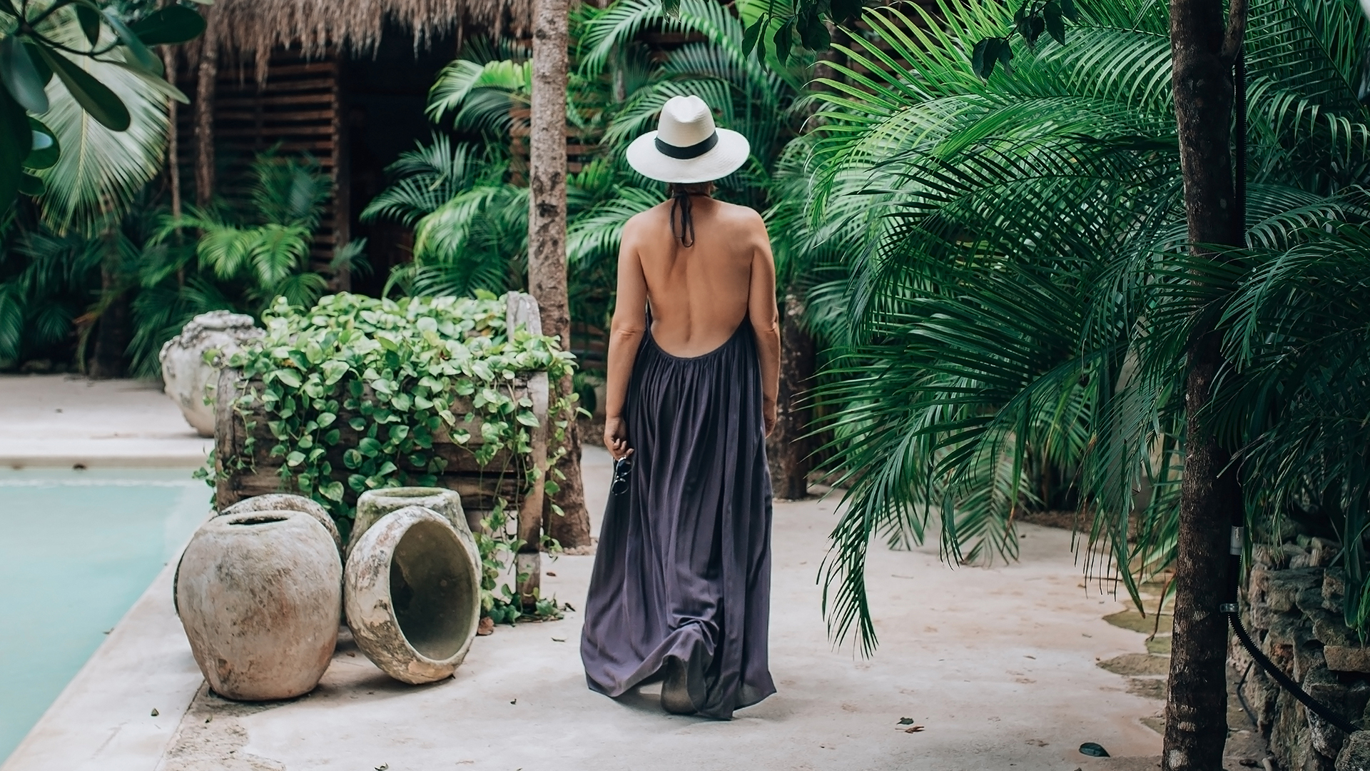 A woman walking in a tropical area.
