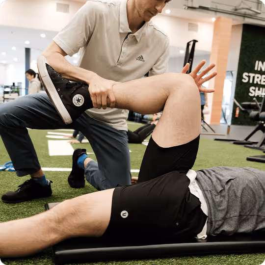 Physical therapist assisting a patient with a knee stretch in a Vancouver physiotherapy clinic.
