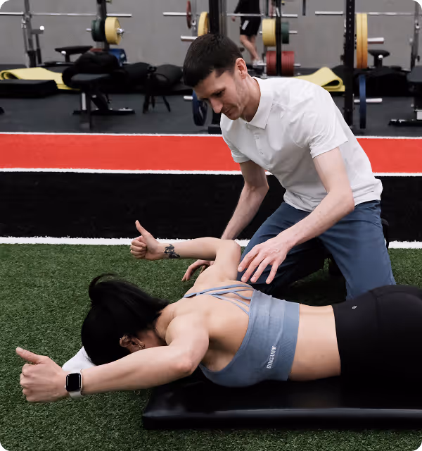 Physical therapist assisting patient with a back extension exercise in a Vancouver physiotherapy clinic.