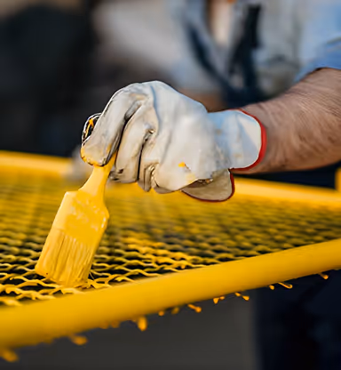 Painter painting a metal fence