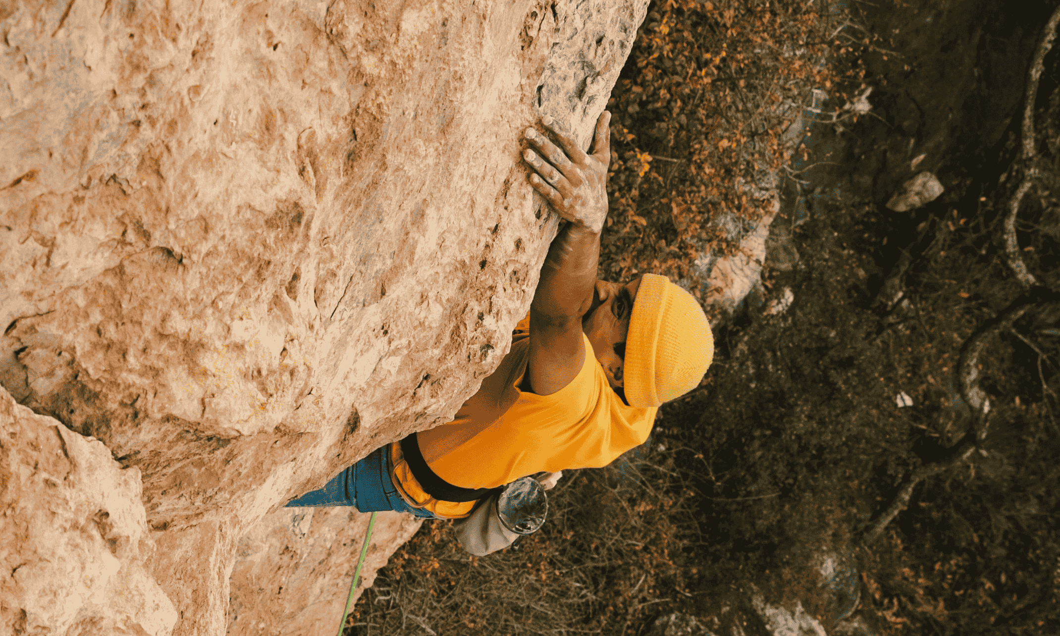 Mountain climber holding on to the side of a cliff